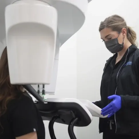 A team member positioning the practice's cone beam CT scanner.