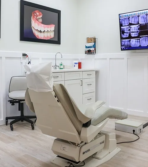 A second treatment room, with a full-arch restoration pictured on the wall.